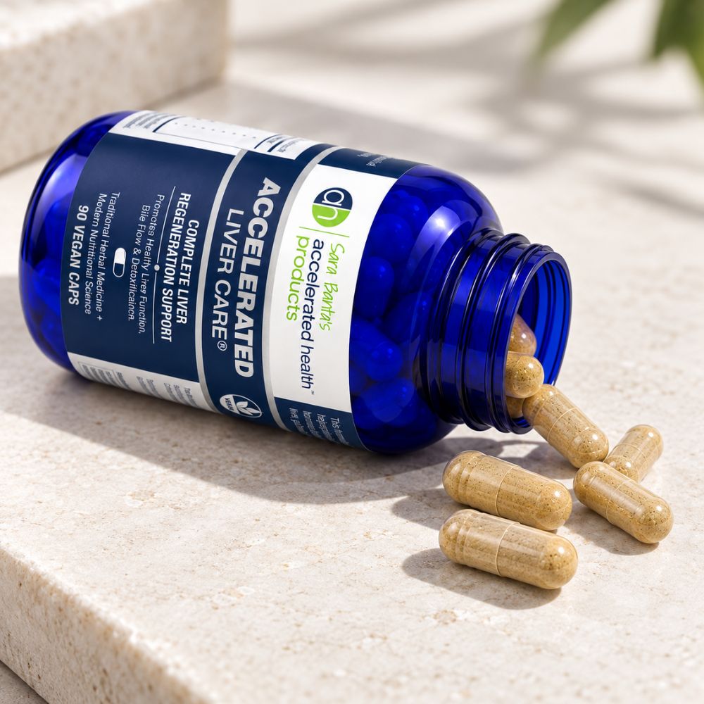 A blue bottle of Sara Banta's Accelerated Liver Care capsules lies on its side on a light beige stone surface, with several tan capsules spilling out.